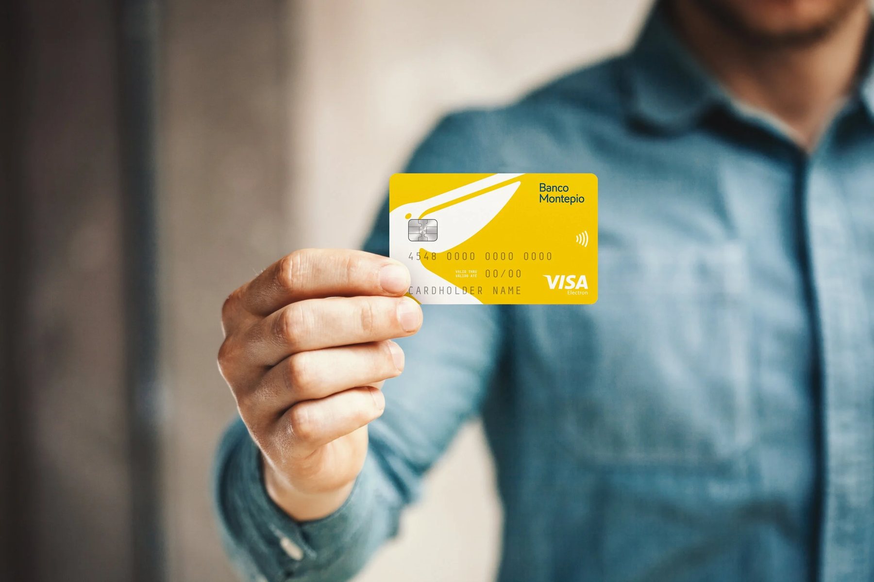 Hand holding the new yellow Banco Montepio debit card