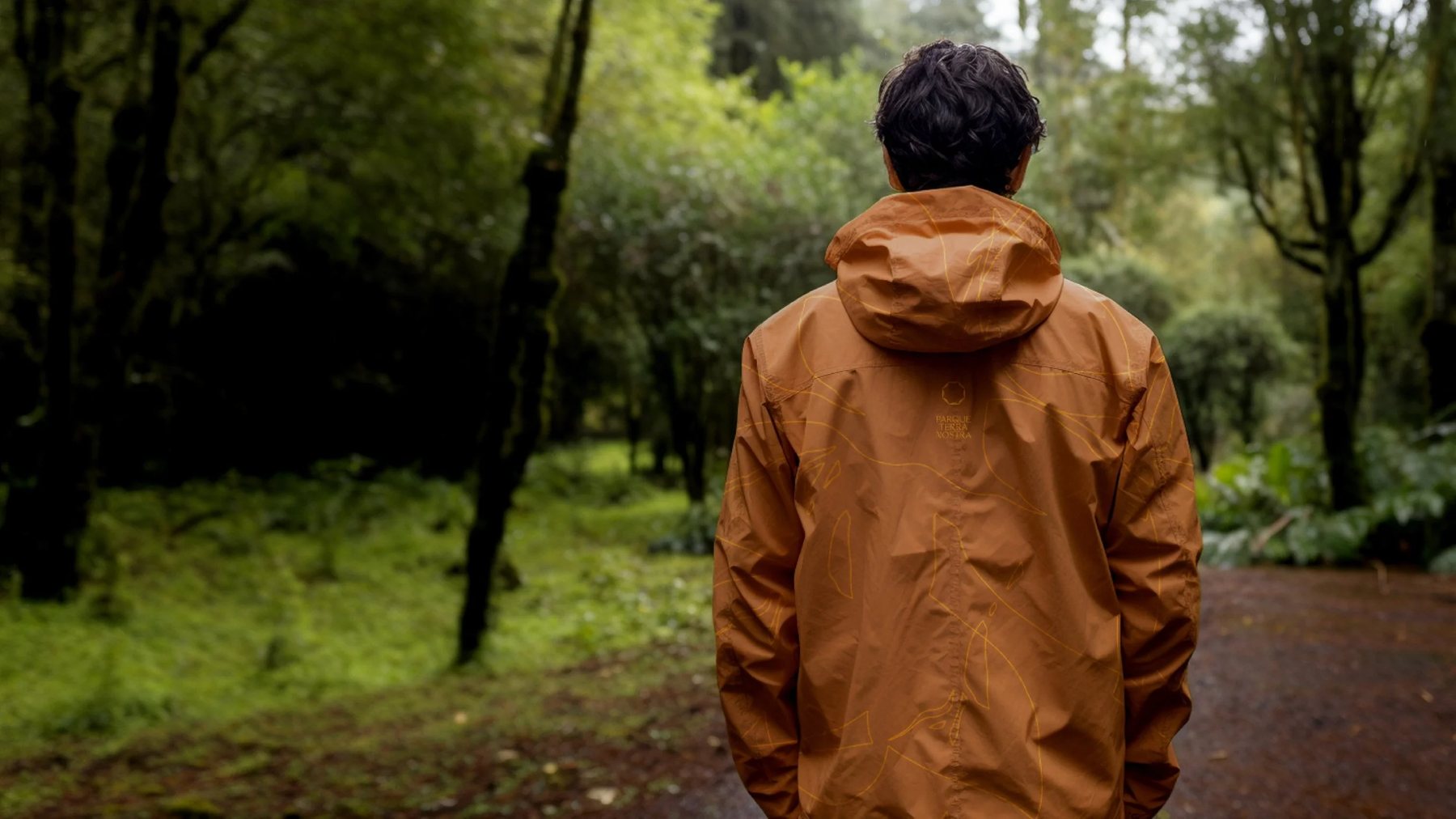 Person in an orange raincoat in the forest