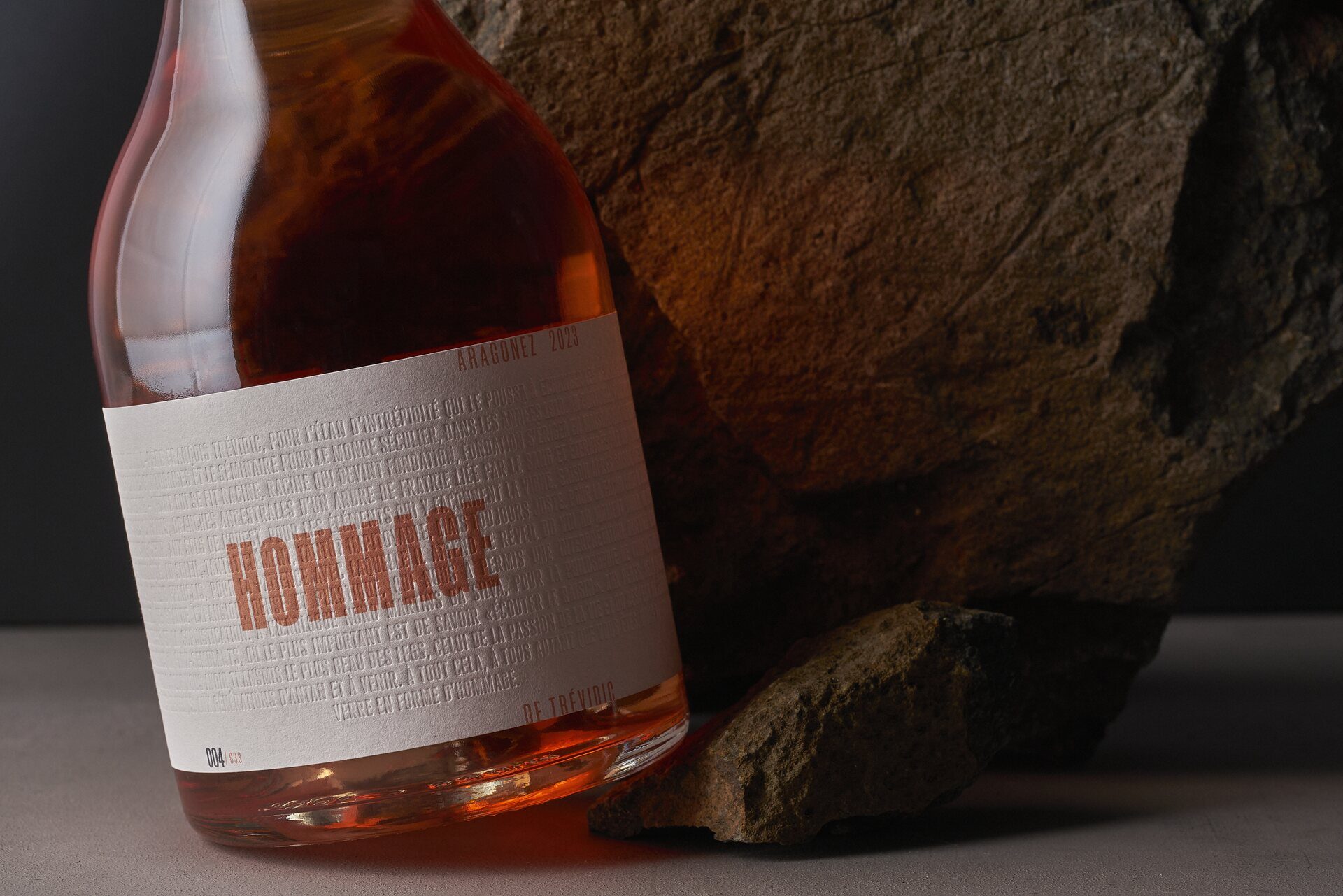 Hommage rosé beside a stone